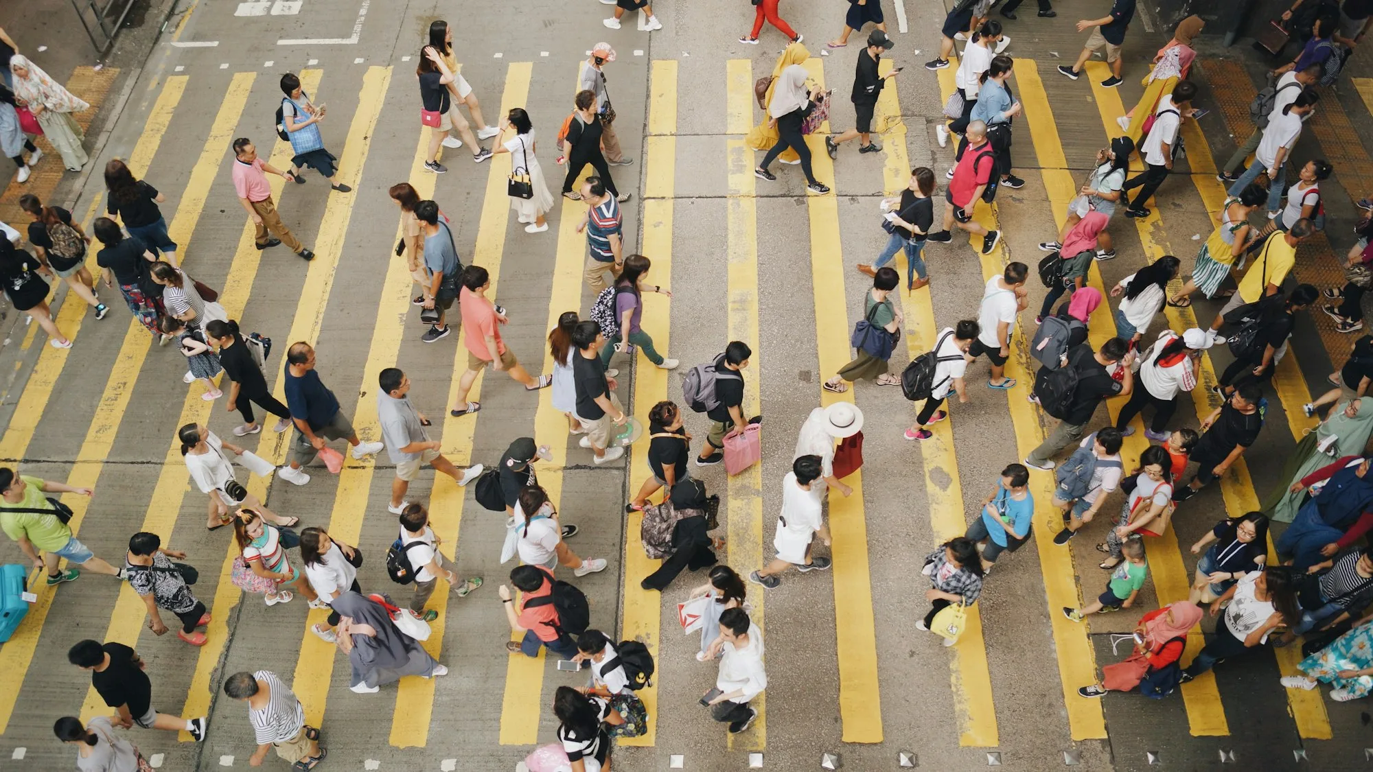 Crowd crossing a Hong Kong intersection at midday